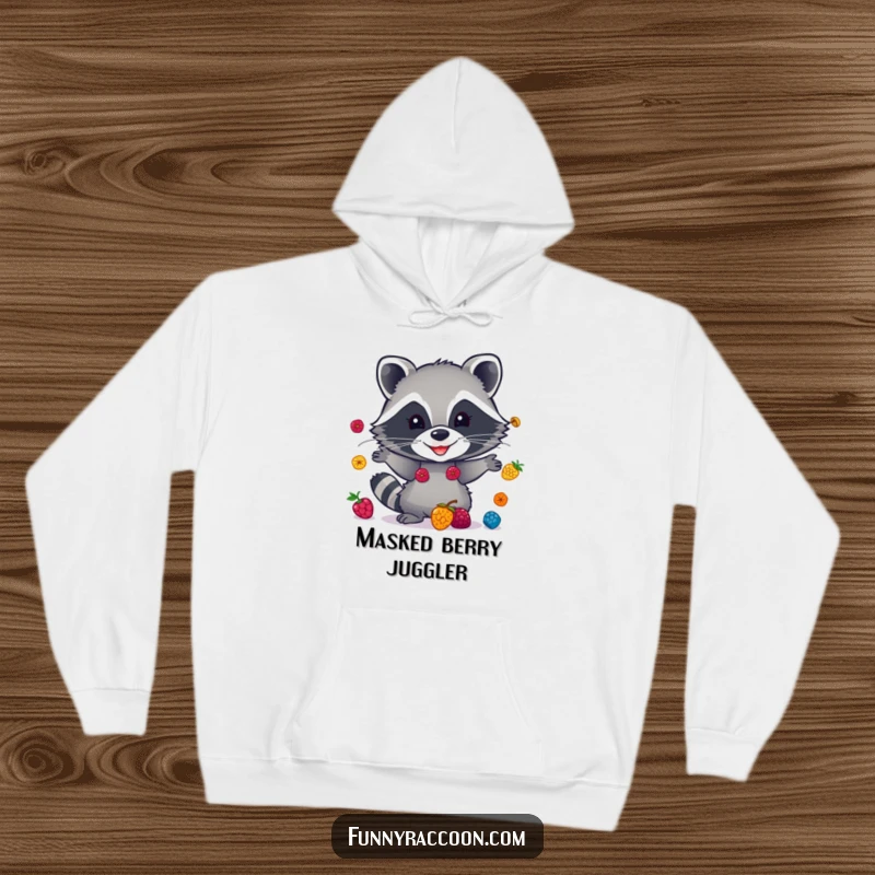 Funny raccoon hoodie, cozy and warm, juggling vibrant berries with a cheeky grin, perfect for cool days and laughs.