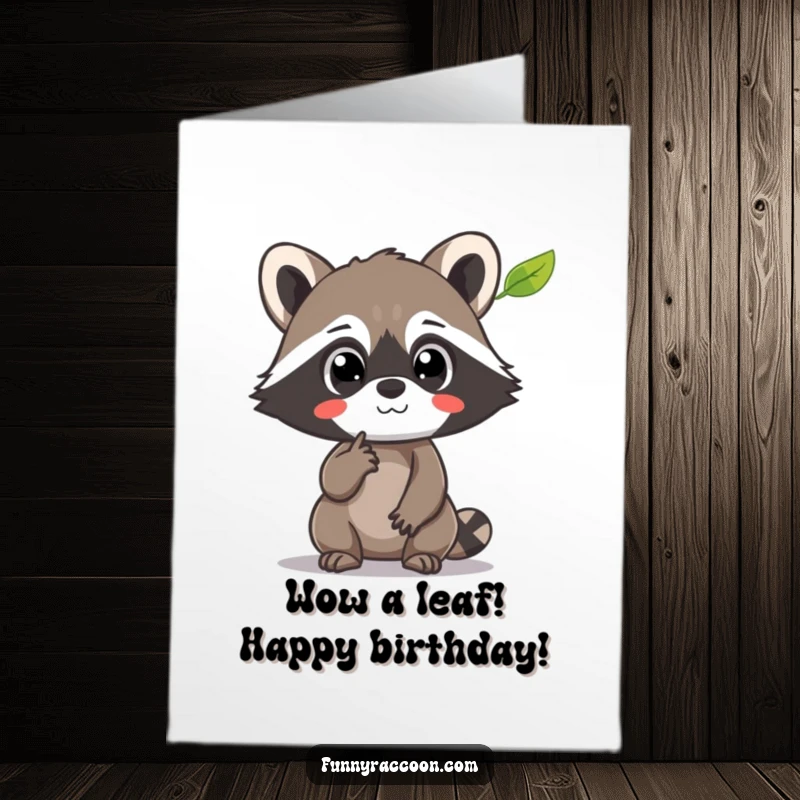 Funny Free Printable Birthday Card: Raccoon with wide eyes pointing at a floating leaf
