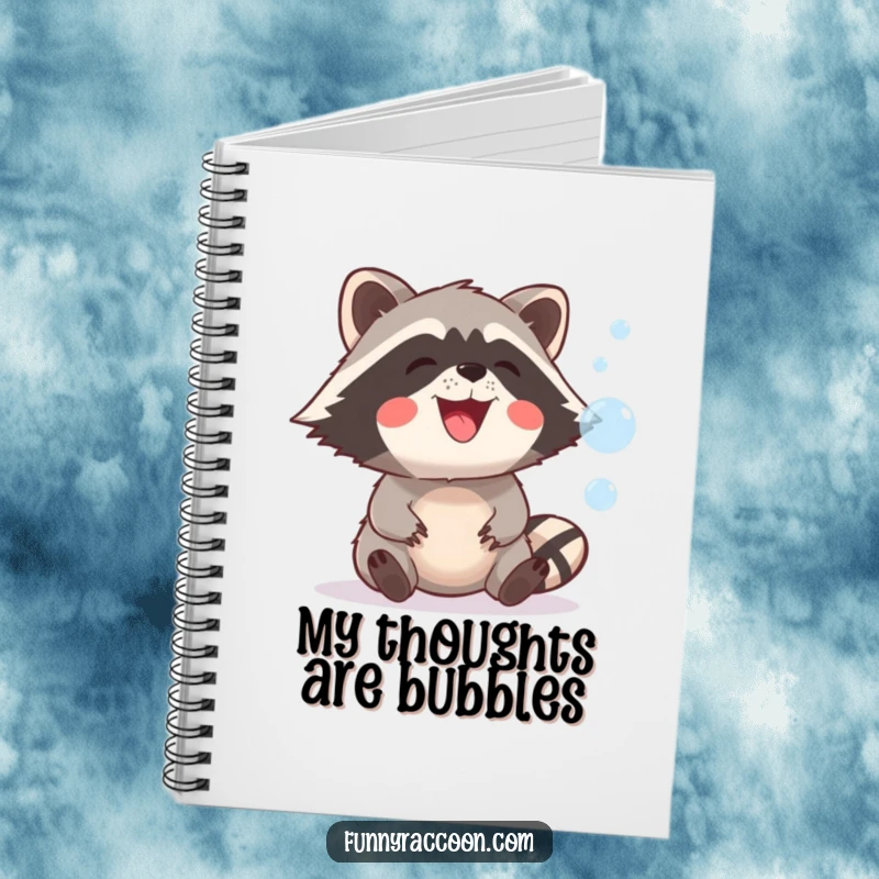 Funny raccoon with a wide, playful grin is depicted on notebook cover, catching floating bubbles, perfect for creative writing.