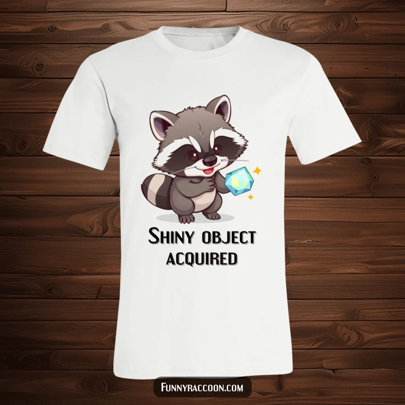 Funny Raccoon T-Shirt: A sly raccoon grins, caught in the act of stealing a dazzling gem, perfect for humor enthusiasts.